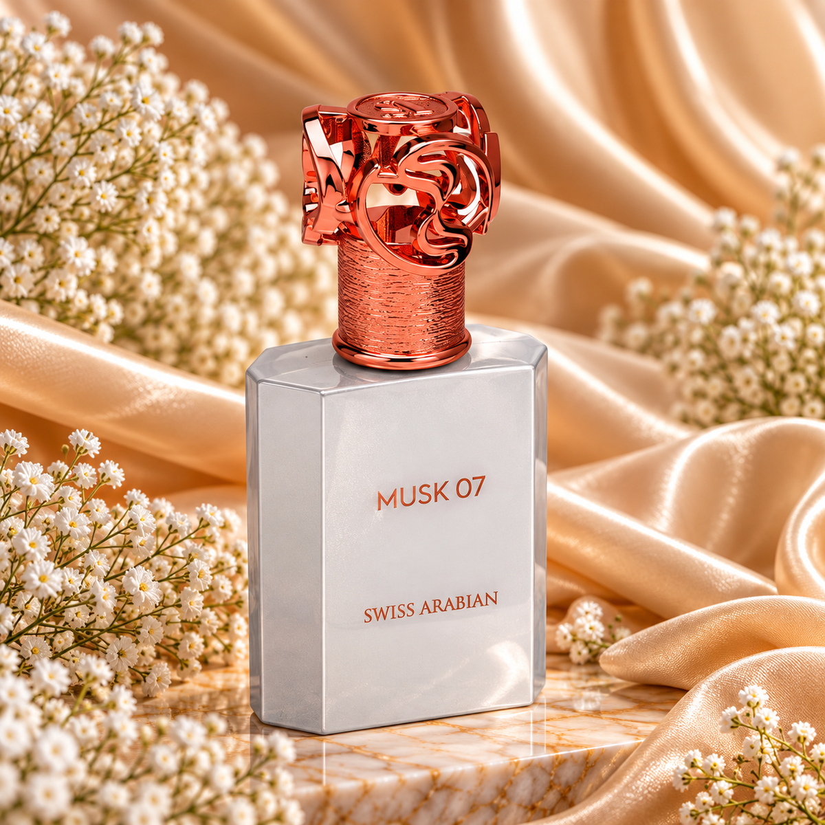 Frasco de Musk 07 Swiss Arabian com acabamento prateado e tampa trabalhada em tom cobre, sobre tecido acetinado dourado e rodeado de flores brancas.

