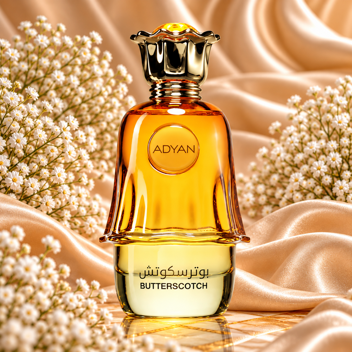 Frasco dourado e âmbar de Butterscotch Adyan, com tampa dourada trabalhada, sobre tecido acetinado e rodeado de flores brancas.