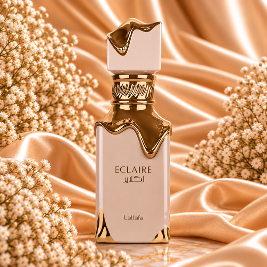 Frasco de Eclaire Lattafa em tom creme, com detalhes dourados de efeito escorrido, sobre tecido acetinado dourado e rodeado de pequenas flores brancas.