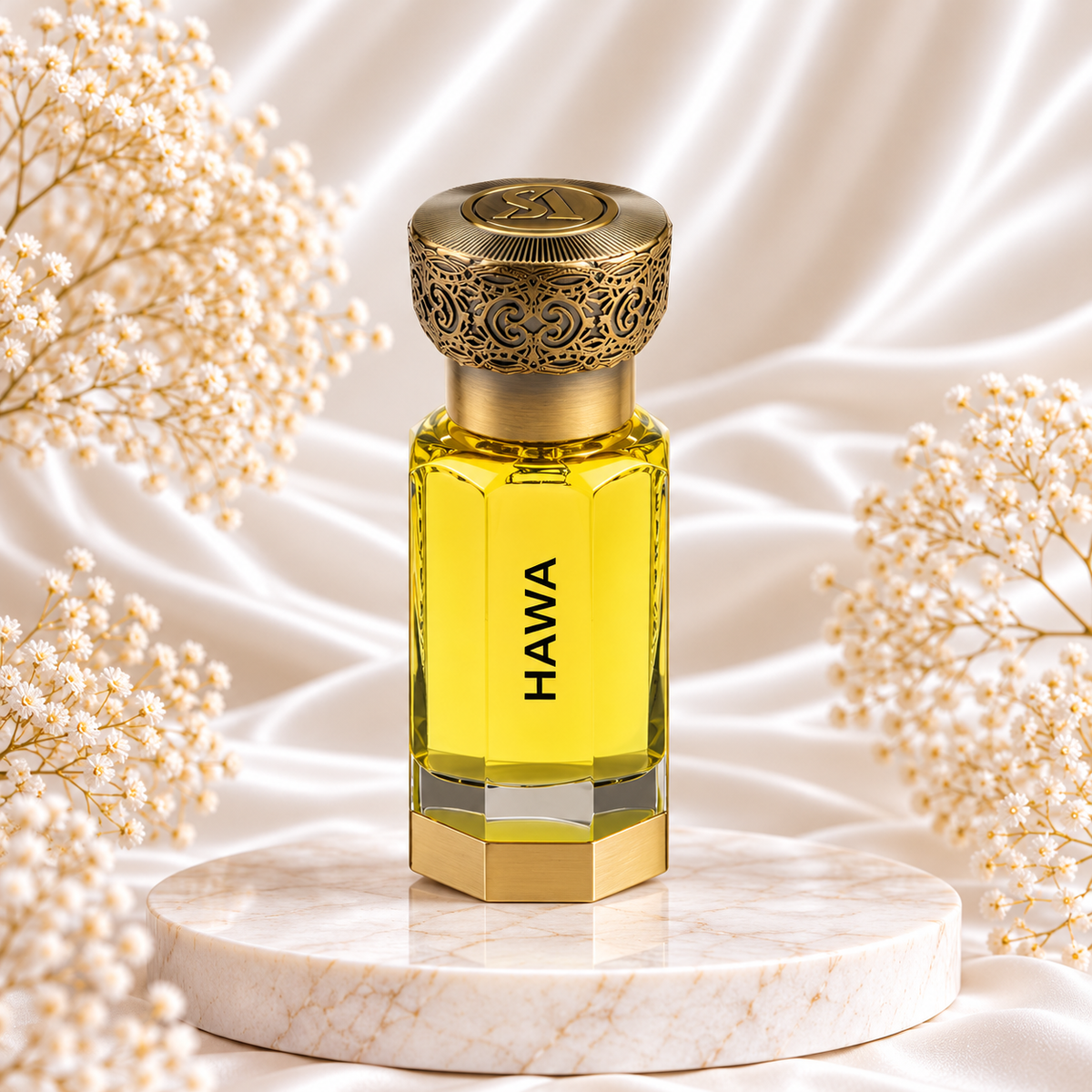 Frasco de óleo perfumado Hawa Swiss Arabian, com líquido amarelo, base dourada e tampa dourada trabalhada, sobre mármore, entre pequenas flores brancas e tecido acetinado claro.